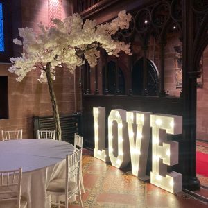 light up letters spelling love and winter trees decoration and table