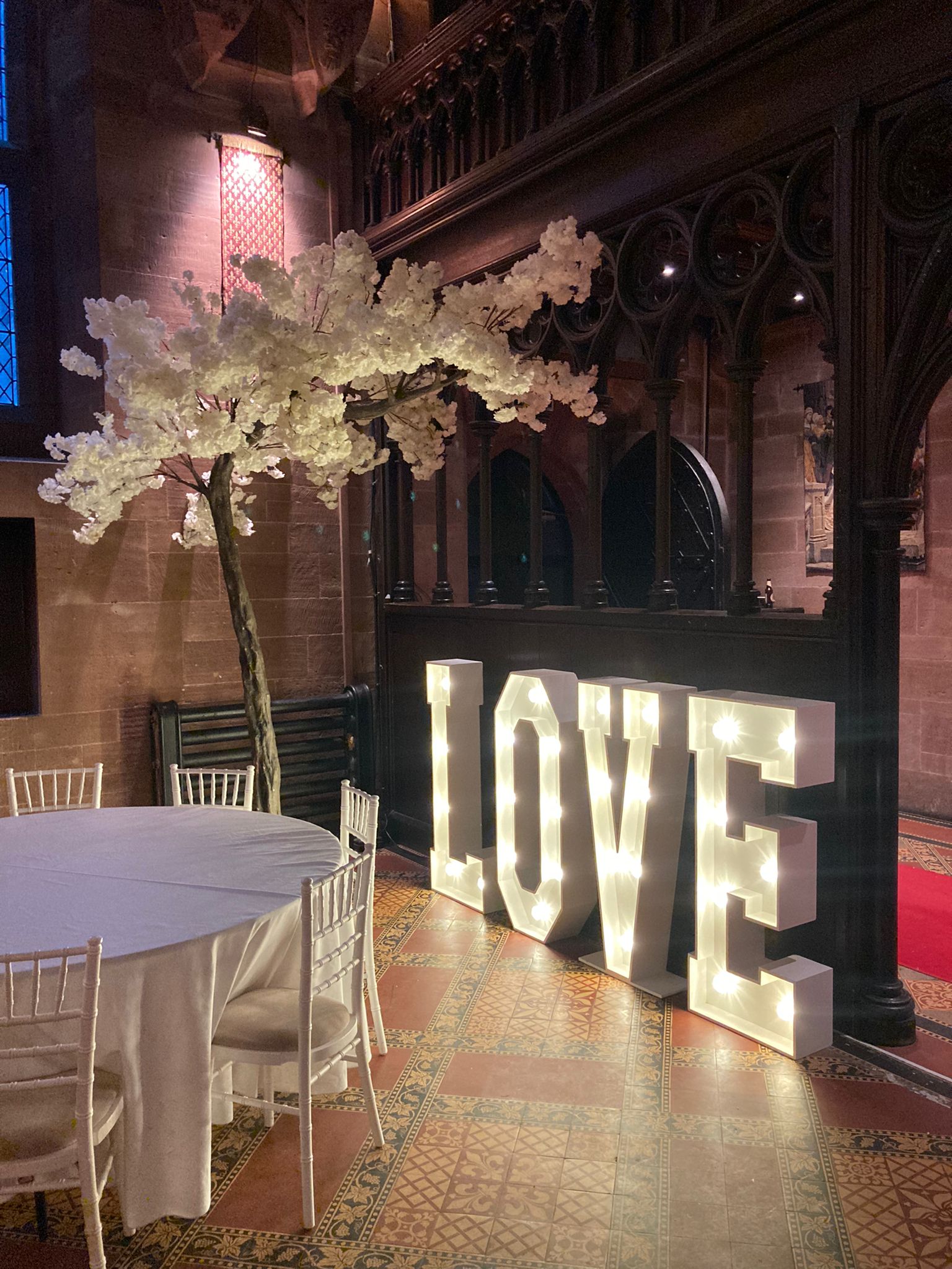 wedding venue with decor blossom trees with light up letters spelling LOVE