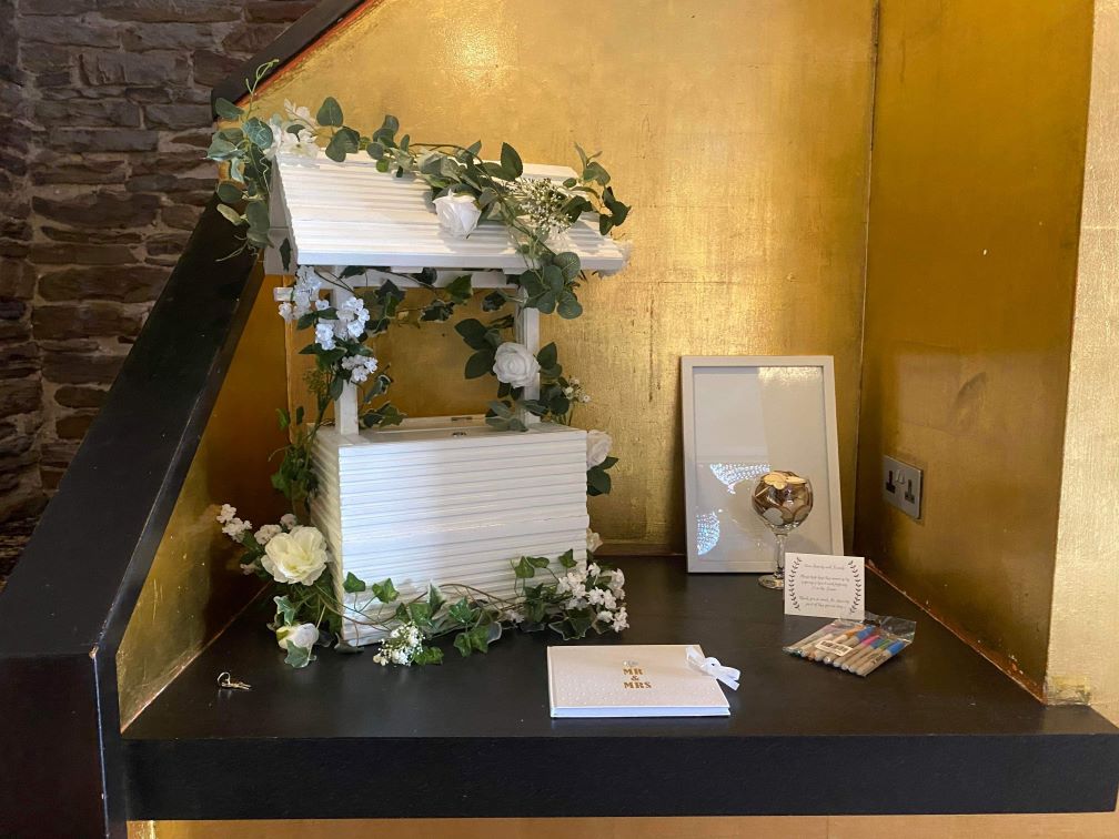 white wooden miniature wishing well for use at weddings for cards and gifts